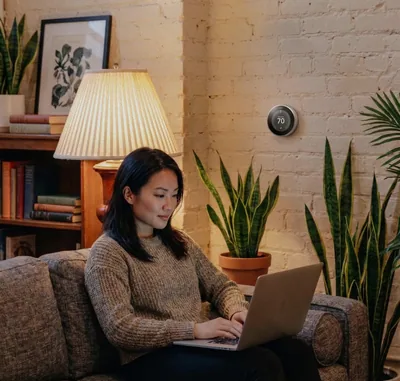 A woman working on a laptop on her couch